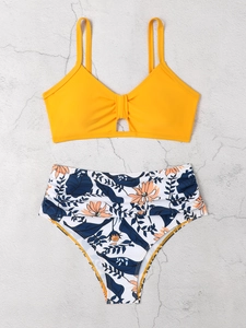 Flachbild von gelbem Bikini-Oberteil mit Ringen und geblümter High-Waist-Hose