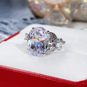 Macro detail of oval faceted gemstone ring with intricate hollow shoulder design