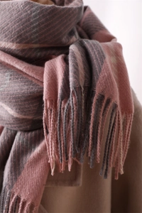 Detailed macro view of pink and grey plaid scarf texture and soft tassel fringe