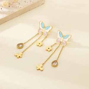 Close-up of golden butterfly earrings with blue-pink gradient and dangling tassels