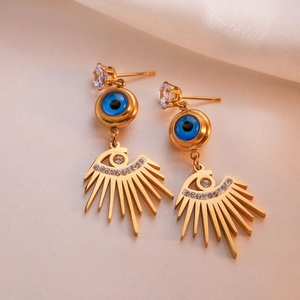 Gold-plated geometric evil eye drop earrings with zircons on pink satin fabric background