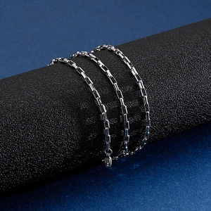 Macro detail of silver stainless steel box chain showing interlocked square link texture