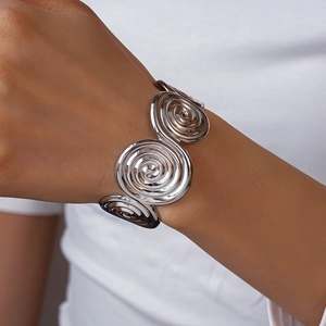 Detail of silver spiral geometric open cuff bracelet with four textured metal discs