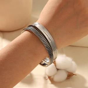 Vintage geometric feather arrow cuff bracelet in silver finish on a model wrist