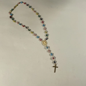 Detailed view of colorful evil eye beaded necklace with Virgin Mary medal and cross