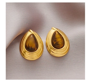 Macro detail of vintage gold stud earrings featuring tear-drop shape tiger eye stones