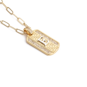 Détail du collier à maillons trombone dorés avec pendentif lettre E serti de zircons