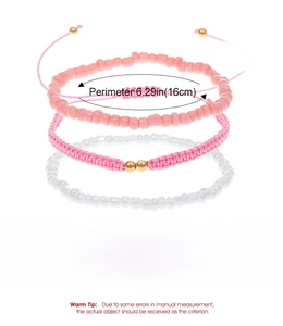 Close-up of three handmade woven bracelets with pink and white beads and gold accents