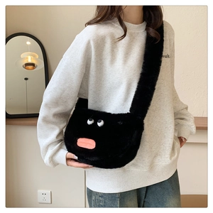 Detail shot of a black fuzzy crossbody bag with funny cartoon eyes and pink thick lips