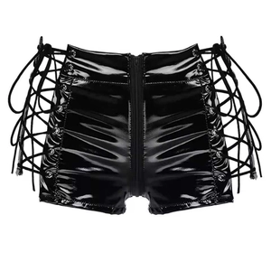 Dettaglio di pantaloncini in pelle verniciata nera lucida con lacci laterali e zip in metallo