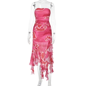 Détail d'une robe bustier rose pêche avec ourlet asymétrique à volants et imprimé fleuri