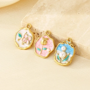 Détail de trois pendentifs vintage en émail doré 18 carats avec perles sur pierre