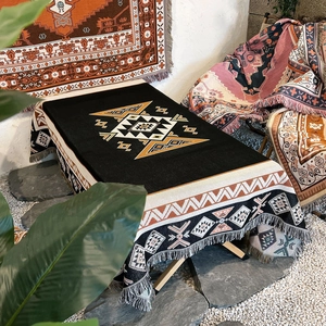 Detailed view of woven camping blanket with bohemian geometric patterns and fringe edges