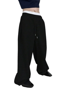 Detail of black wide-leg joggers featuring elastic waist and matching drawstring design