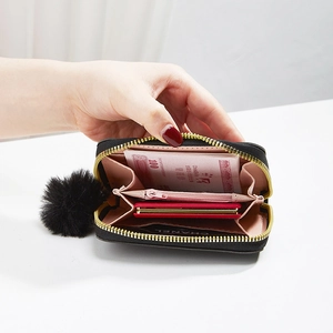 Mini black plush heart coin purse with golden zipper and fluffy ball keychain detail