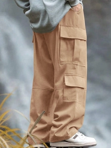 Vista dettagliata dei pantaloni cargo kaki in twill di cotone con tasche multiuso esterne