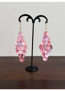 Detailed view of layered pink shell tassel drop earrings with golden hooks