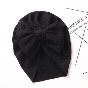 Detailed view of black textured baby turban hat with a large decorative bow
