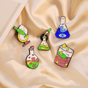 5-piece science lab enamel pin set featuring colorful flasks and microscopes on satin fabric