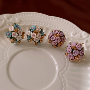 Macro shot of cluster ceramic flower earrings with pink and purple rose designs