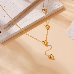 Minimalist gold plated stainless steel Y-necklace with four 3D heart pendants on stone