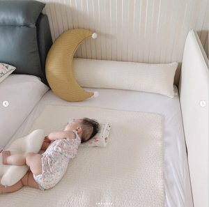 Quilted moon nursing pillow and matching cloud cushions set in a cozy nursery bedroom