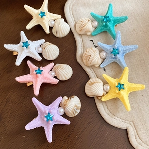 Detailed overhead shot of seven starfish shell hair clips with pearls and rhinestones