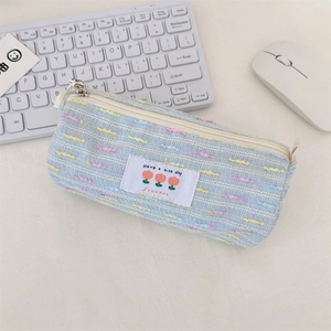 Primer plano del estuche de tweed azul con parche de tulipa en escritorio minimalista