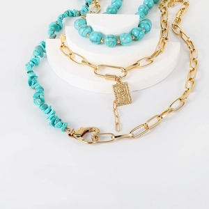 Asymmetric turquoise bead necklace with chunky gold chain and rose relief pendant