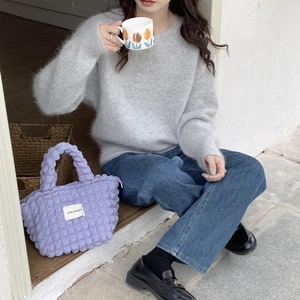 Detail shot of a purple quilted canvas handbag with Love Sozakka label on an autumn outfit