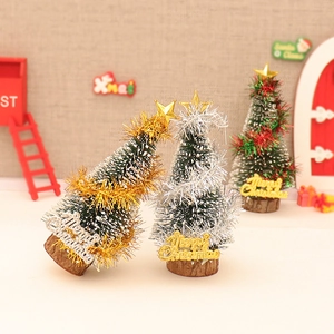 Three mini green Christmas trees with gold, silver, and red tinsel and wooden bases