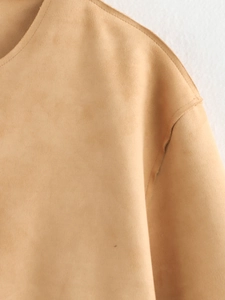 Close-up of crew neckline and shoulder stitching on a camel faux suede bomber jacket