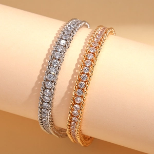 Elegant gold and silver chain bracelets with sparkling rhinestones on a warm backdrop