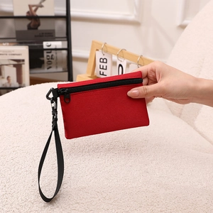 Porte-monnaie minimaliste en tissu rouge avec fermeture éclair noire et dragonne