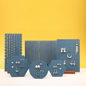 Teal jewelry display set for earrings and necklaces on yellow background
