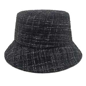 Close-up of black tweed bucket hat with woven texture and white metallic threads