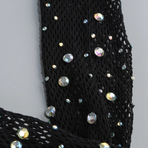 Detail of black mesh dress featuring colorful AB rhinestones and intricate knit texture