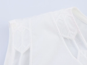 Gros plan détaillé sur tissu en coton blanc avec broderie géométrique et motifs ajourés