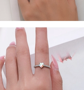 Dettaglio di un anello in argento con opale a cuore e piccoli diamanti al dito