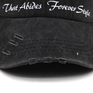 Close-up of distressed vintage black baseball cap with white letter embroidery details