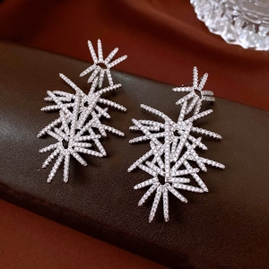 Detailed view of silver fireworks pendant earrings with sparkling cubic zirconia on leather