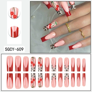 Long ballerina press-on nails with red French tips, leopard print, and cherry rhinestones