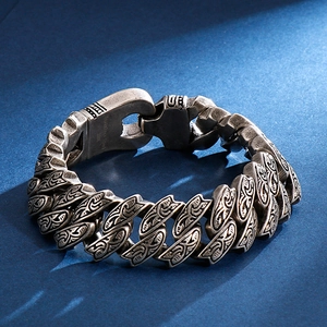 Detail of vintage 316L stainless steel bracelet with engraved patterns on deep blue background