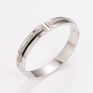 Macro shot of silver stainless steel T-motif bracelet with sparkling white diamonds