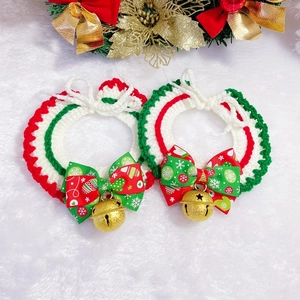 Detail of hand-knitted Christmas pet collars with festive bows and golden metal bells
