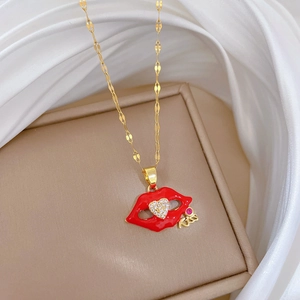Detailed close-up of a red lip pendant necklace with a tiny gold Kiss motif on silk