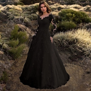 Close-up of intricate black floral lace texture and long sleeves on off-shoulder dress
