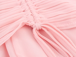 Detailed close-up of pink pleated chiffon fabric with adjustable drawstring knot design