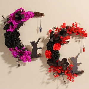 Handmade crescent moon wreaths with black cats and roses for Halloween home decor.