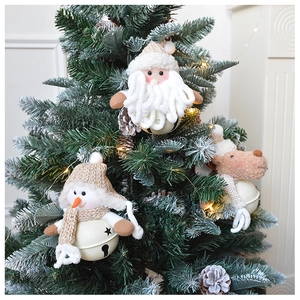 Detail of plush Santa, Snowman, and Reindeer bells hanging on a decorated Christmas tree